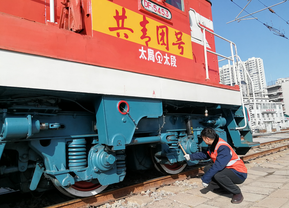 刘文杰检查DF7-5453“共青团号”调车机走行部。