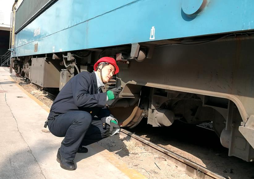 韩文盛全神贯注检查机车走行部。