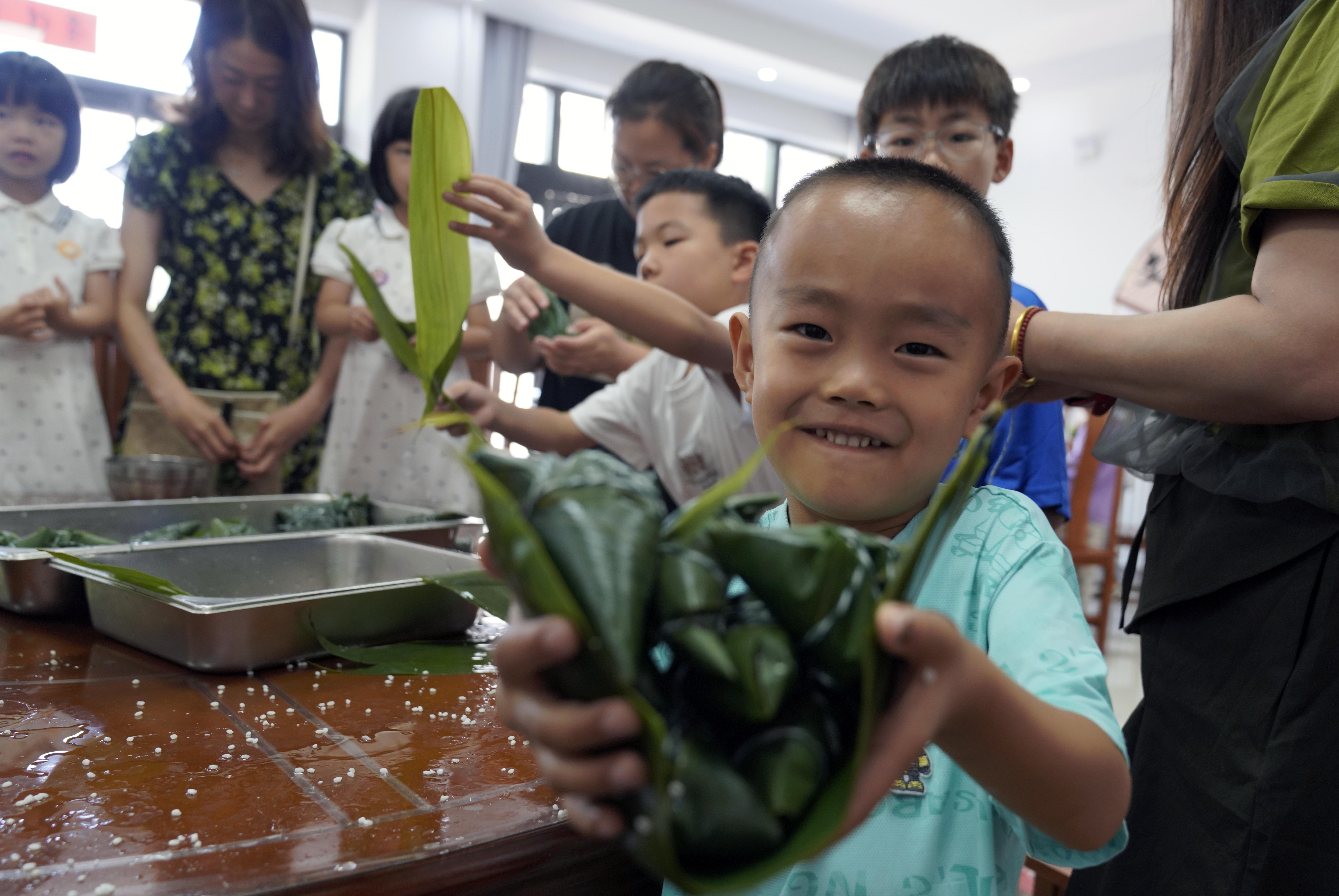 志愿者的孩子与福利院的孩子们包粽子