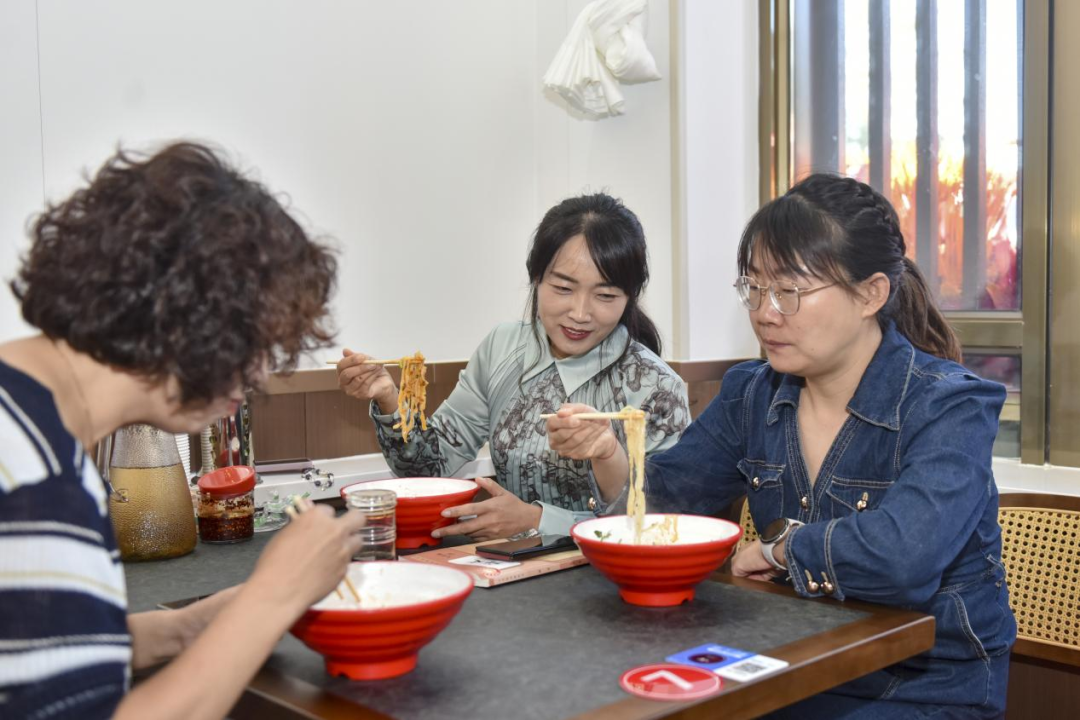 ▲山西援疆教师杨睿琪在“晋味斋”面馆品尝家乡风味 配图1